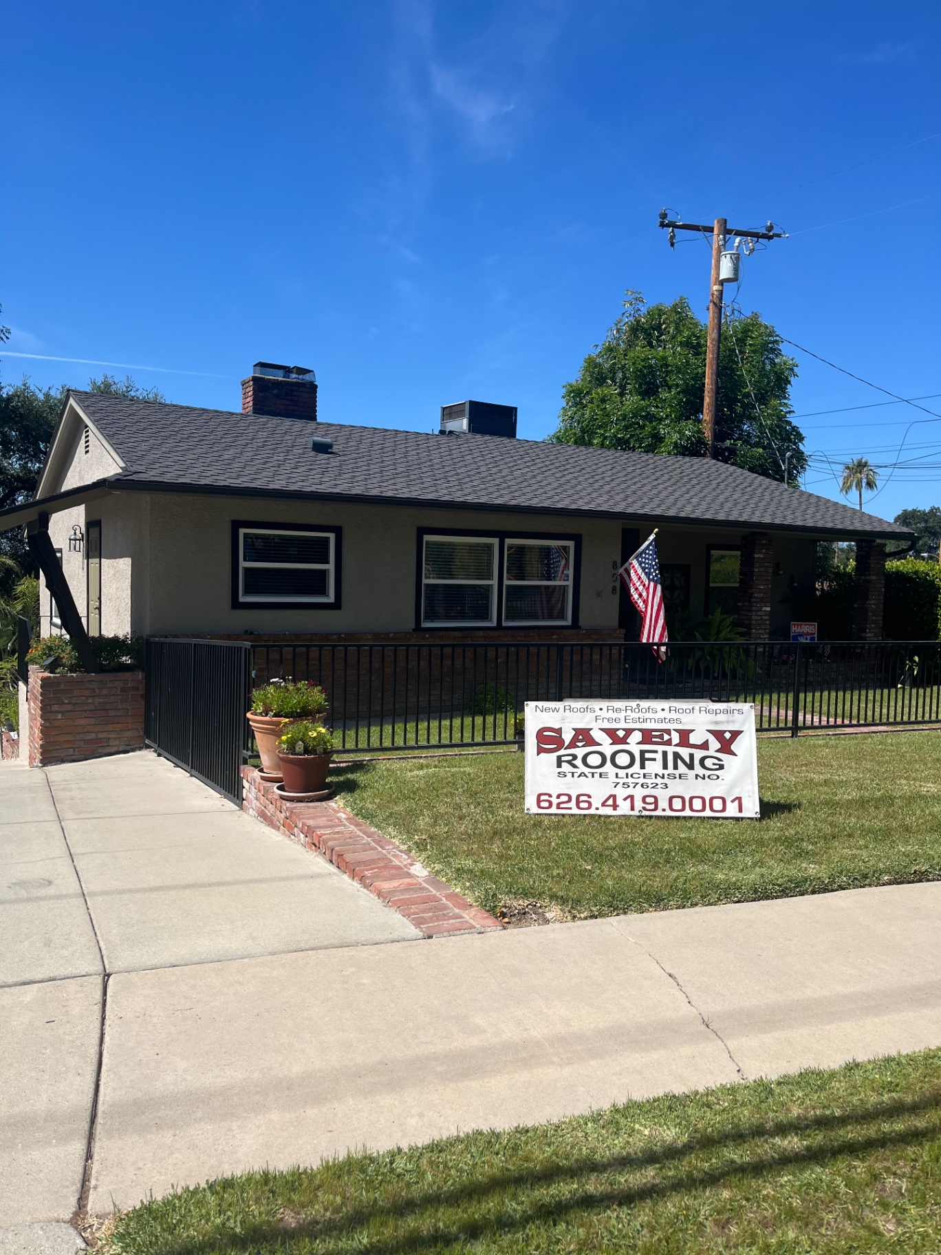 Completed roof with Savely Roofing yard sign
